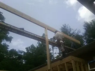 Carpenter setting a ridge beam over a new addition frame — Ice Dam Removal by Roofing Brothers in Fort Madison