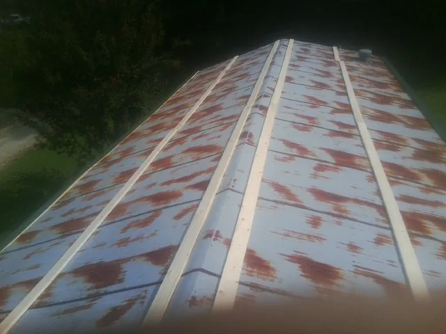 Rusted metal roof panels with new wood purlins before replacement — Storm Damage Roof Repair in Fort Madison by Roofing Brothers