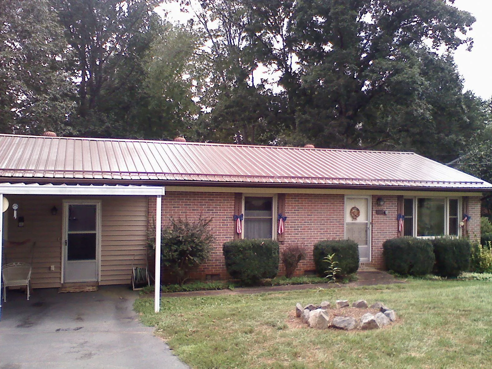 Bronze metal roof and carport on a brick ranch home — Roof Repair work by our crew in Fort Madison